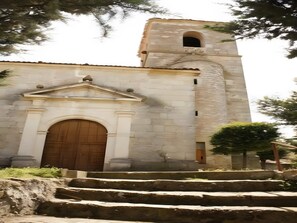 A stone building with a central arched doorway and a bell tower. - Country House 'Reoyo 2' with Shared Garden and Wi-Fi (Mambrilla de Castrejón)