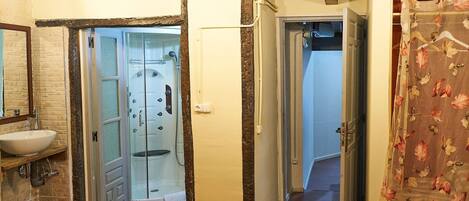 Un baño con cabina de ducha de vidrio, un lavabo y un espejo.