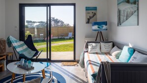 Una habitación con una cama, una silla, una mesa y un cuadro en la pared.