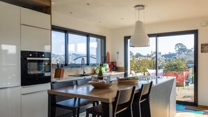 Una cocina moderna con una isla grande, electrodomésticos de acero inoxidable y vistas a la ciudad.