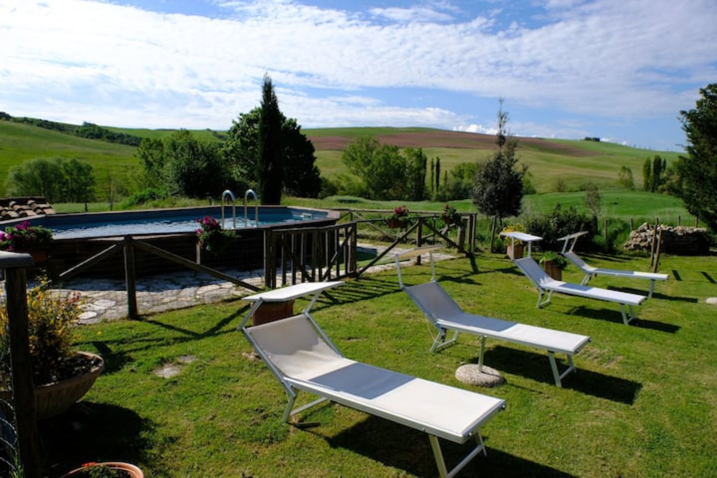 Ein Poolbereich mit Liegestühlen und einem Whirlpool.