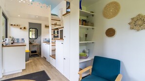 A compact living space with a kitchenette, a dining area, and a seating area. - Tiny House in Saint-Cernin-de-l'Herm – Shared Pool & Relaxing Stay for 4 Guests (SAINT-CERNIN-DE-L'HERM)