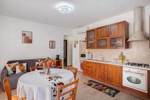 Uma cozinha compacta com armários de madeira, fogão a gás e micro-ondas.