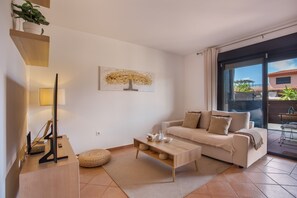 Una sala de estar moderna con un sofá, una mesa de centro y una obra de arte en la pared.