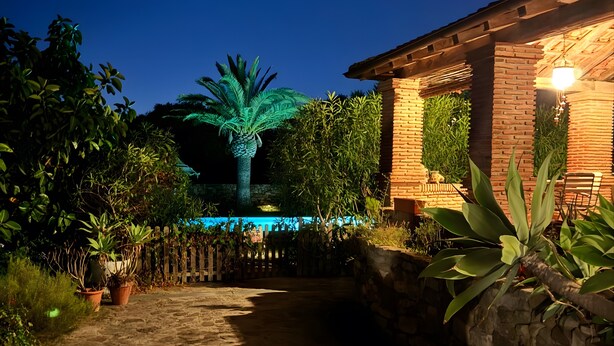 A paved pathway leading to a building with a brick facade and a stone wall. - Apartment 'Casa Rural Maximón Azul' with Sea Views, Wi-Fi and Air Conditioning (Los Caños de Meca)