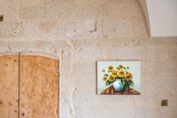A wall with a wooden door and a painting of sunflowers.