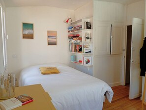 A bedroom with a bed, a bookshelf, and a door.