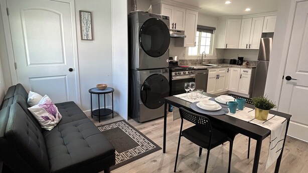 Un espacio habitable pequeño con sofá, mesa de comedor y kitchenette.