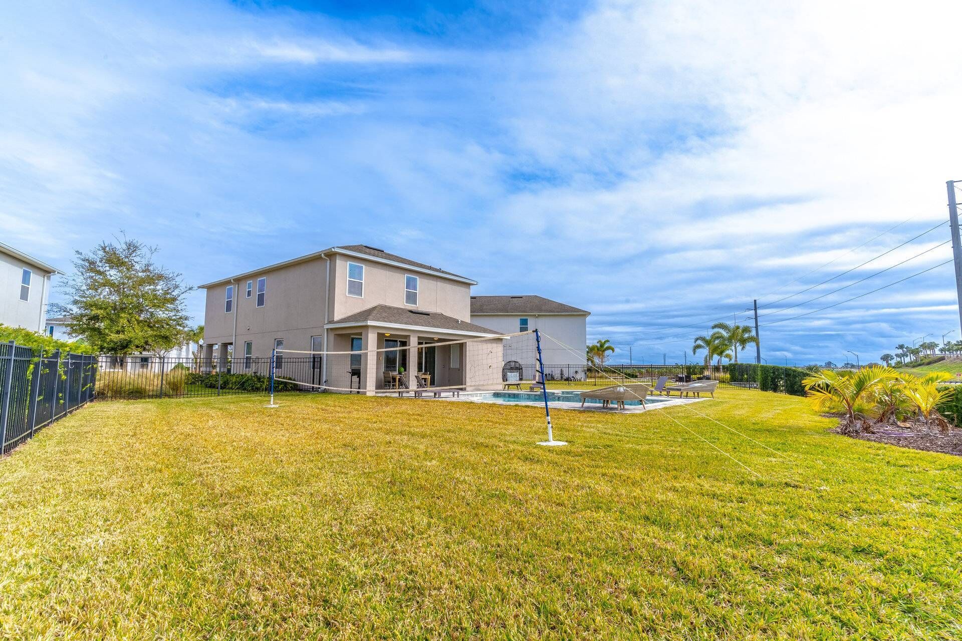 A two-story house with a covered patio and a swimming pool.