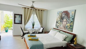 A bedroom with a bed, bedside table, nightstand, chair, table, and a ceiling fan. -  Pelican Key Studio-pool, near the beach. The best area on Dutch side! (Pelican Key)