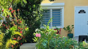 A pathway leading to a building with a white door and windows. -  Pelican Key Studio-pool, near the beach. The best area on Dutch side! (Pelican Key)