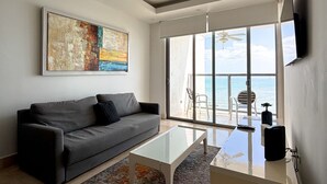 A modern living room with a grey sofa, a glass coffee table, and a colorful rug. - Departamento de lujo Yoo-Panamá 34B  (Panama City)