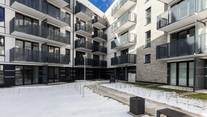 A modern multi-story building with balconies, large windows, and a snow-covered courtyard. - Mostek Sapphire Navy Studio (Gdansk)