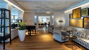 A spacious living room with a piano, sofas, and a dining area in the background. - Mignon (Merano)