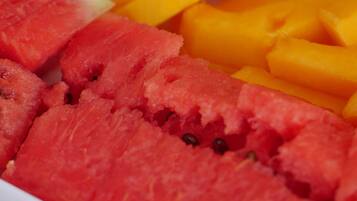 A tray of sliced fruits including watermelon and mangoes.