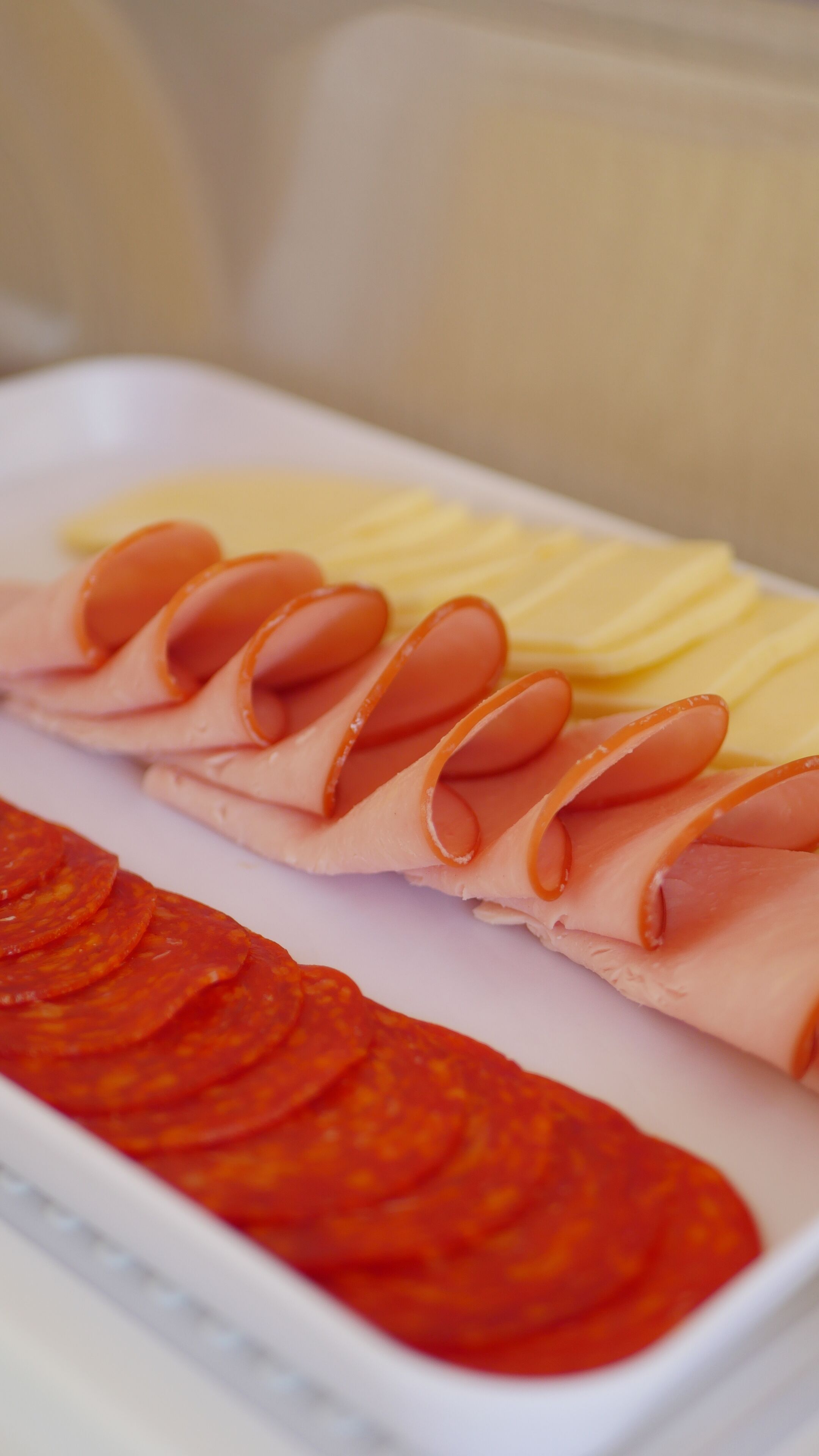 A tray with sliced meats and vegetables.
