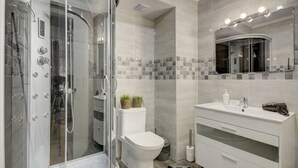 Une salle de bain moderne avec une douche à parois de verre, des toilettes et un meuble-lavabo avec un miroir.