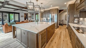 A modern kitchen with a large island, stainless steel appliances, and wooden cabinets. - New + Stunning + Luxury! Lake Access Home + Community Pool! (McHenry)