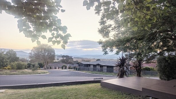 Un barrio residencial con casas, césped y un camino pavimentado.