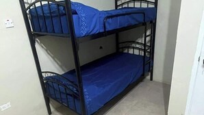 A bunk bed with blue bedding in a room with tiled flooring. - 1 Bed in Shared Dorm - Backpackers Hoatel Montego Bay AC, Fan & hot water (Montego Bay)