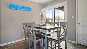 A dining area with a table and chairs, a vase with flowers, and a window with a view of the outdoors. - Centrally Located Apt with Pool in Columbia, MO (Columbia)
