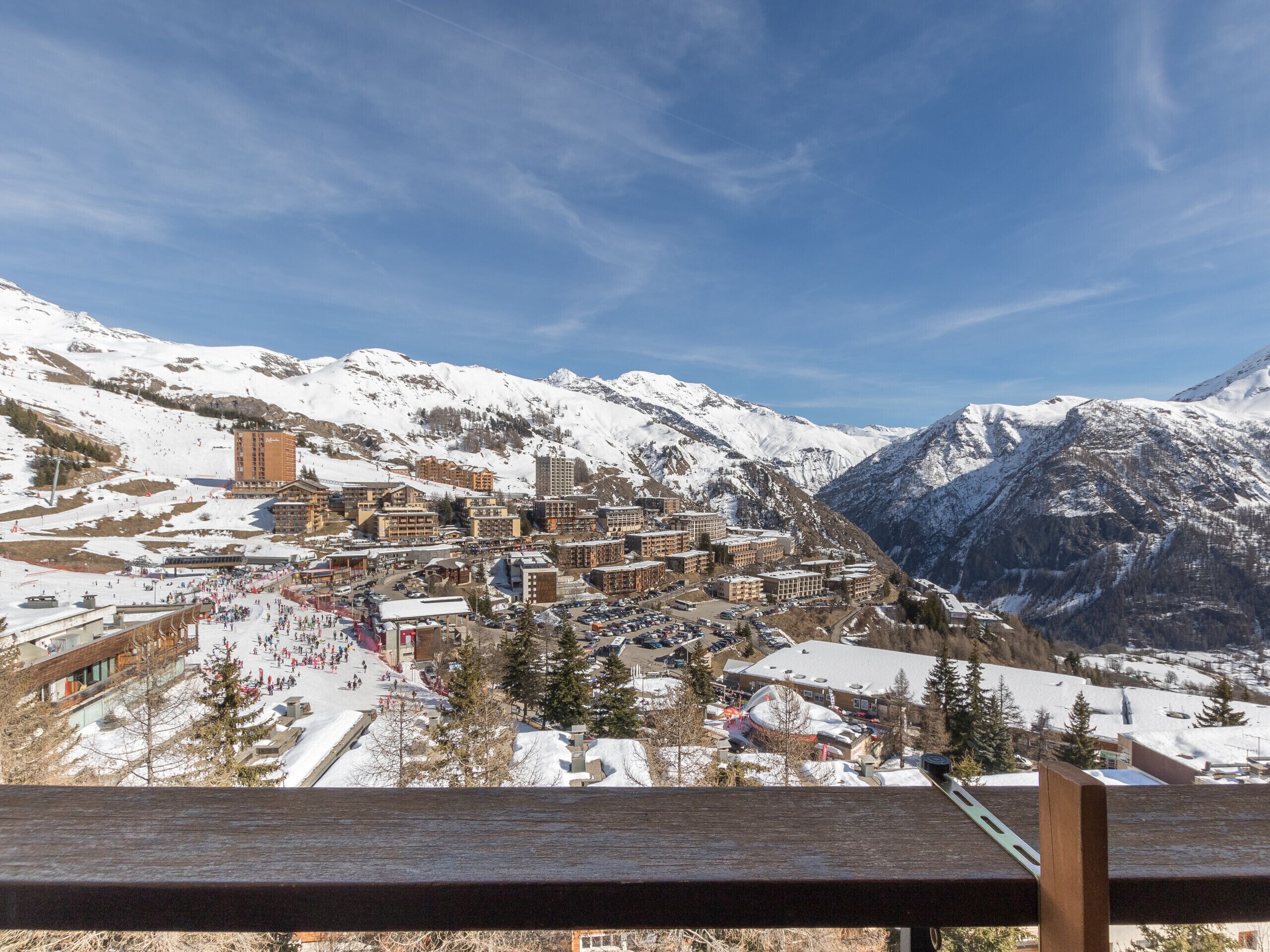 Een bergstad bedekt met sneeuw, met gebouwen, een skigebied en een opvallende toren.