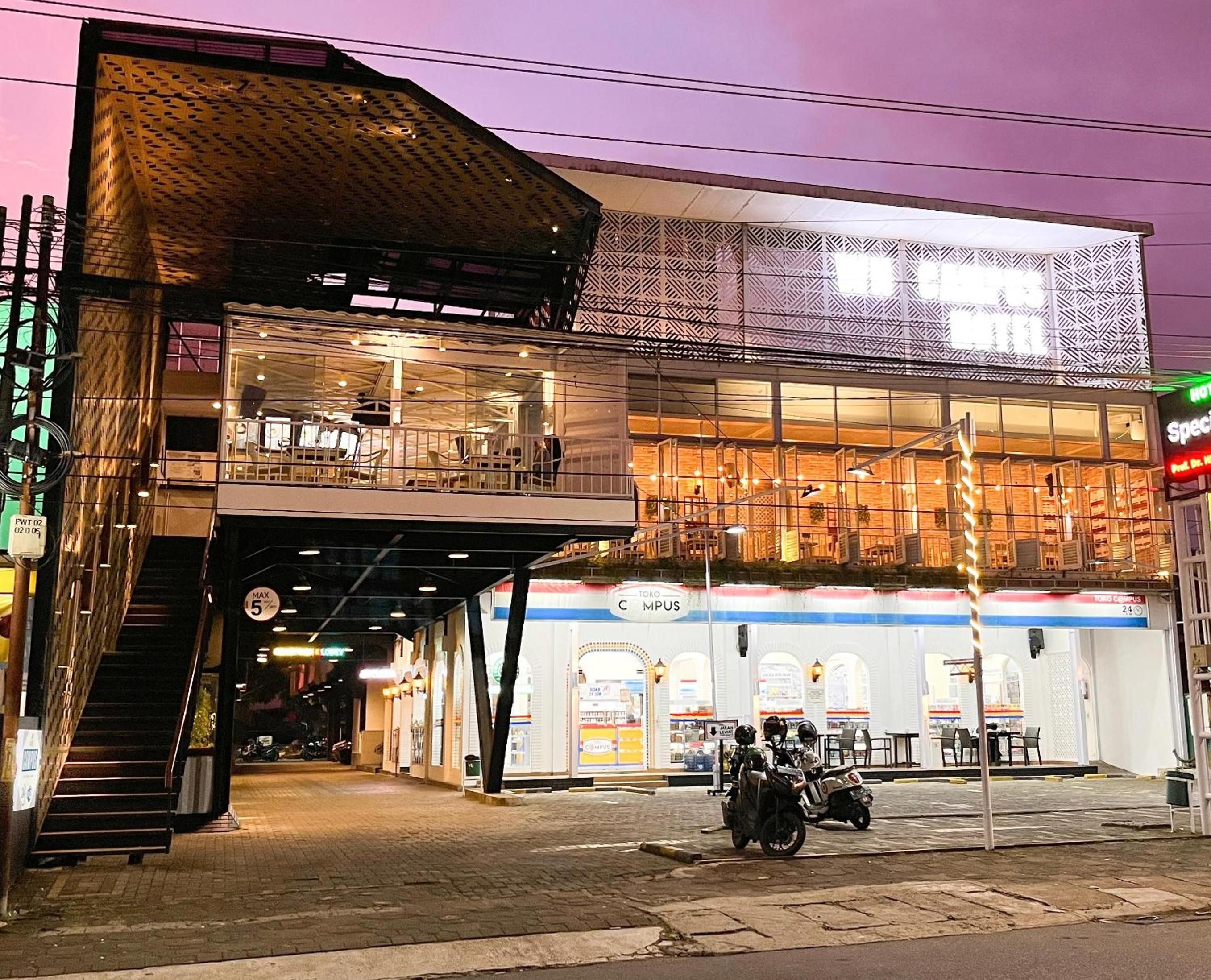 A two-story building with a covered outdoor seating area and a sign indicating a restaurant.