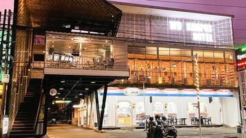 A two-story building with a covered outdoor seating area and a sign indicating a restaurant.