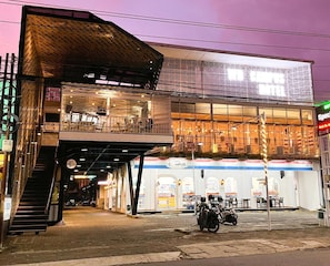 Un edificio de dos pisos con un área de estar techada al aire libre y un letrero que indica restaurante.