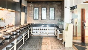 Una cocina moderna con una encimera larga, pared de ladrillo y techo de madera.