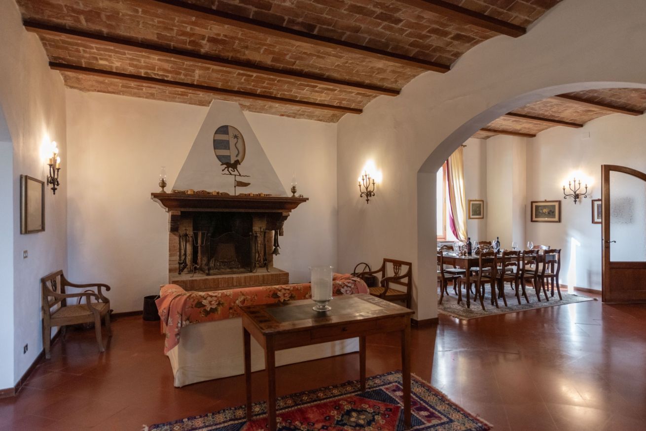 A cozy living room with a fireplace, wooden furniture, and a dining area with a table and chairs.