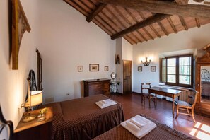 Una habitación con una cama, un escritorio, una silla, una mesa y una ventana.