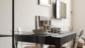 A modern dining area with a dark wooden table, clear glass chairs, and minimalist decor. - One bedroom Corso Garibaldi - Mirable PM (Milano)