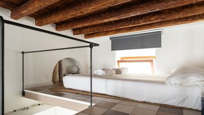 A bedroom with a bunk bed, a window with a blind, and a wooden ceiling. - One bedroom Corso Garibaldi - Mirable PM (Milano)