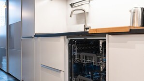 A modern kitchen with a dishwasher, a wooden countertop, and a stainless steel kettle. - One bedroom Corso Garibaldi - Mirable PM (Milano)