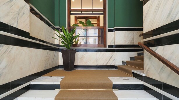 A marble staircase with a wooden handrail, leading to a door with a window. - One bedroom San'Agostino - Mirable PM (Milano)