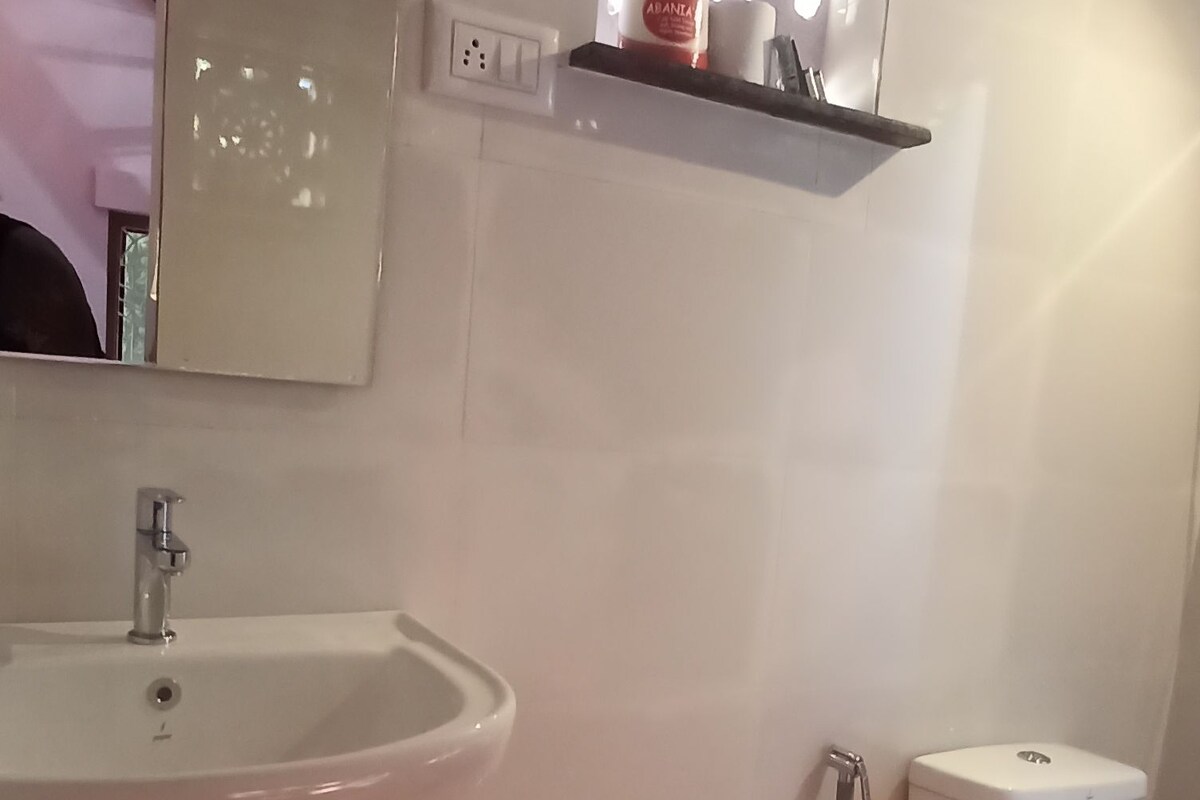 Ein Badezimmer mit Waschbecken, Spiegel, Dusche und Toilette.