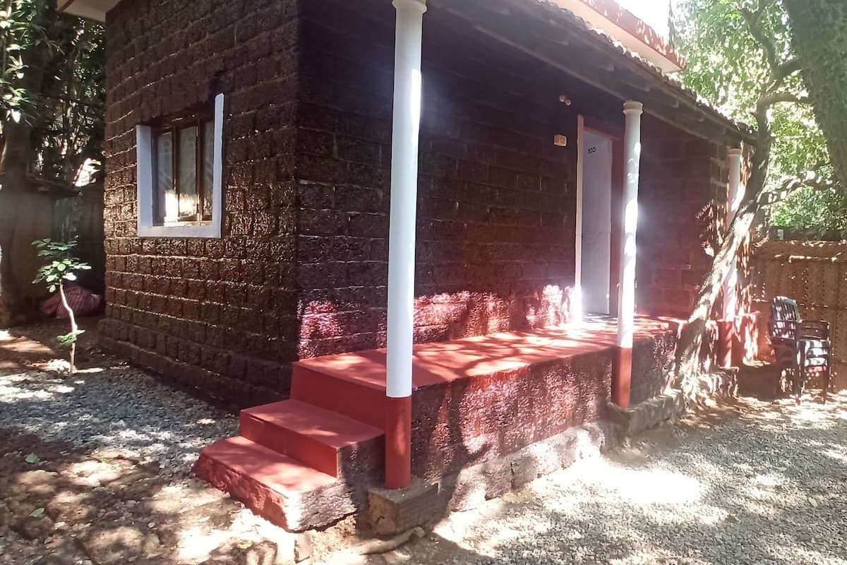 Ein rustikales Holzhäuschen mit Veranda, Treppe und einem eingezäunten Garten.