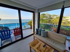 Een balkon met een bank, stoelen en een salontafel.