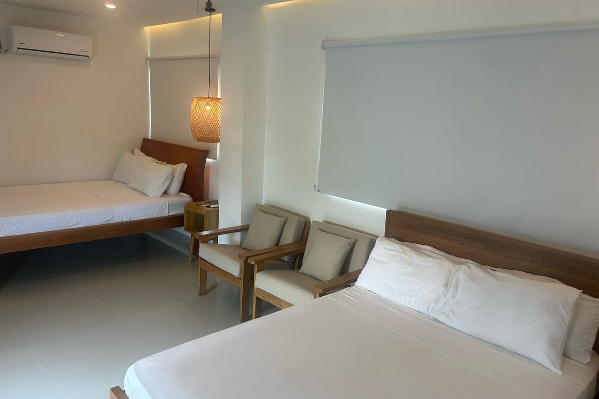 Een moderne hotelkamer met een bed, een stoel en een tafeltje.