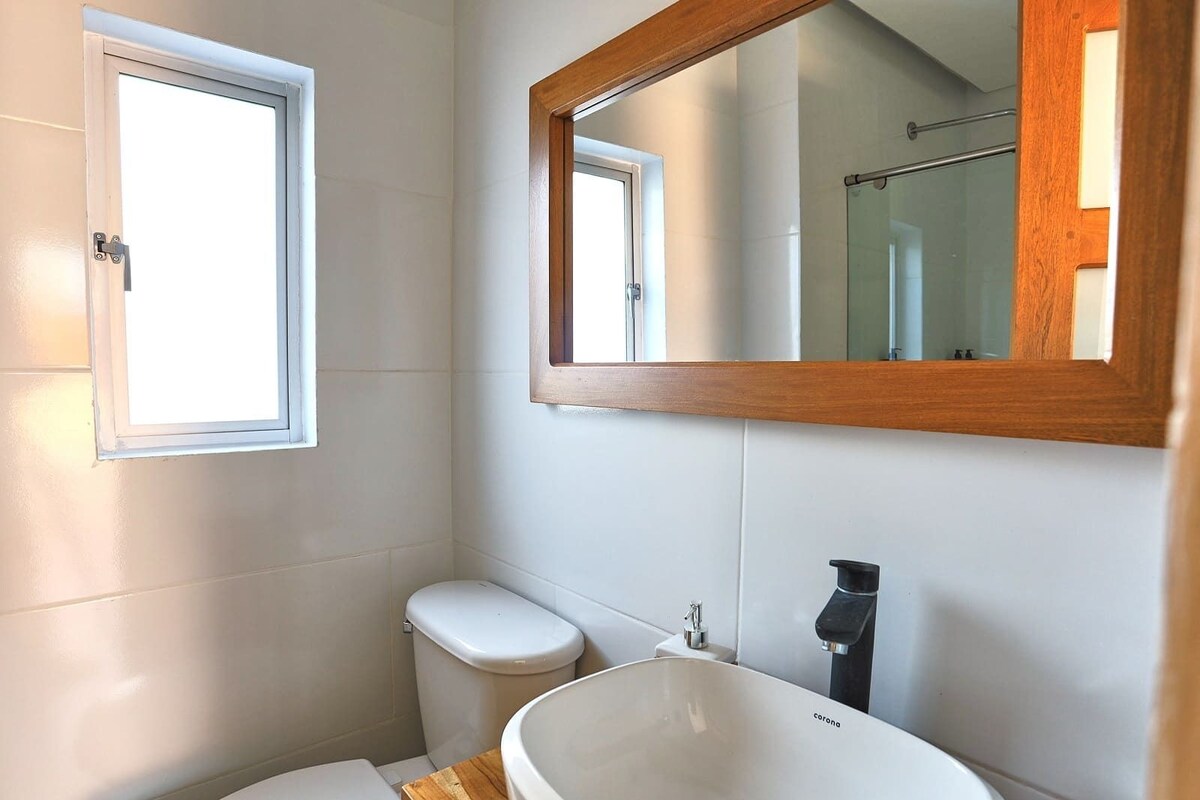 Un baño con inodoro, lavamanos y ventana.