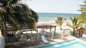A pool area with a view of the beach and ocean.