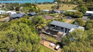 A residential area with houses, a barbecue area, and a view of the sea. - The Island Veranda - Our Island (Waiheke Island)