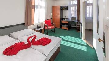 Habitación de hotel con dos camas, un escritorio, una silla y un armario.