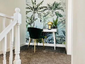 Una habitación con una escalera, un escritorio y una silla.