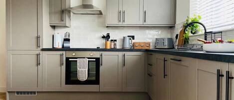 Fridge, dishwasher, high chair, cookware/dishes/utensils