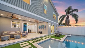 Une maison moderne dotée d’une piscine, de mobilier d’extérieur et d’un espace patio.