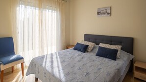 Ein Schlafzimmer mit einem Bett, einem Sessel und einem Nachttisch.