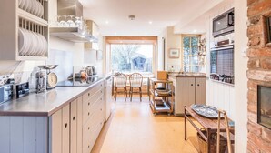 A modern kitchen with a central island, wooden cabinets, and a view to the outdoors.