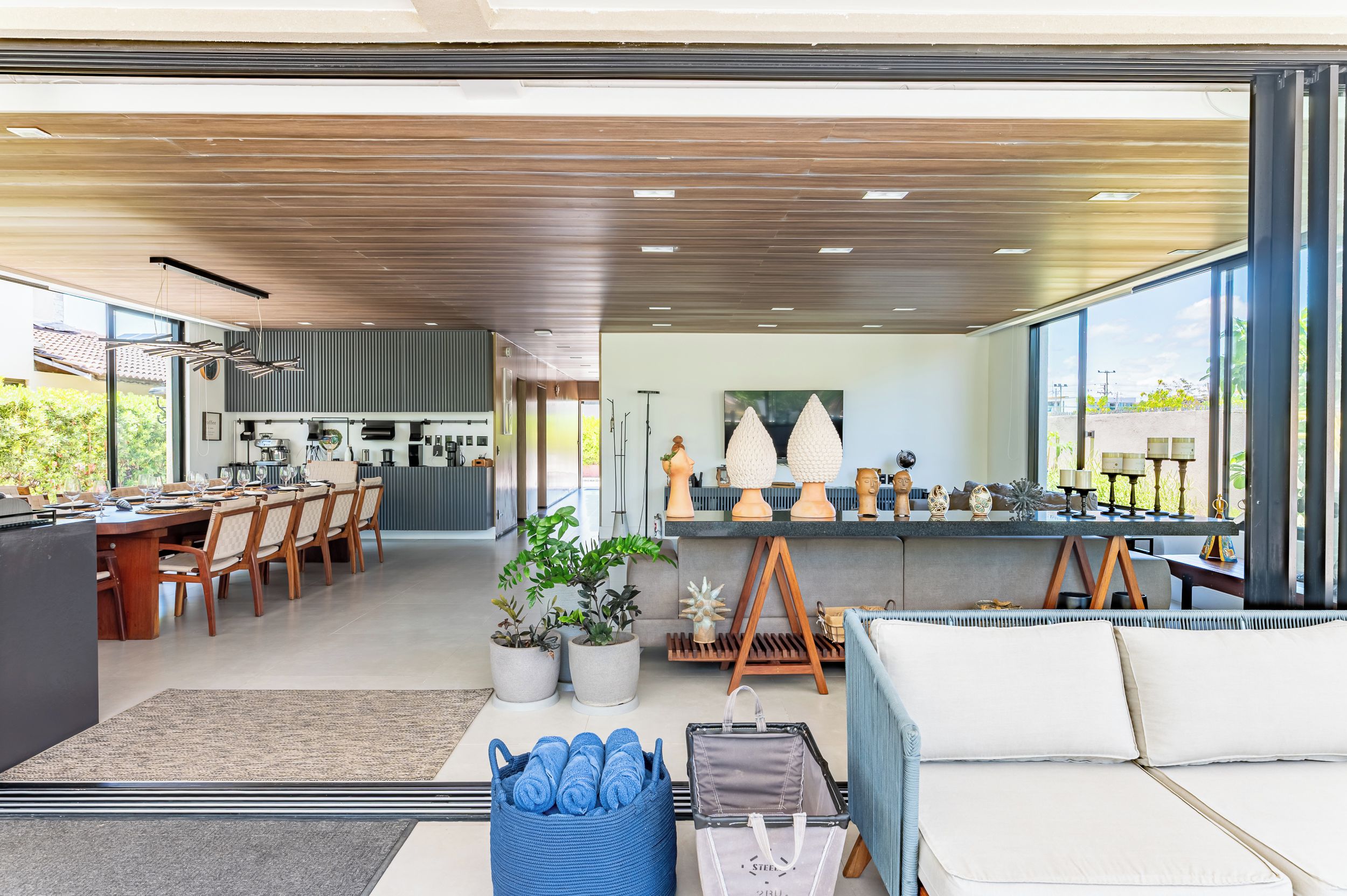 A modern interior with a dining area, kitchen, and seating space with large windows.